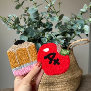 May include: Two felt crafts, a yellow pencil and a red apple with a white stem and a black "A+" on it.