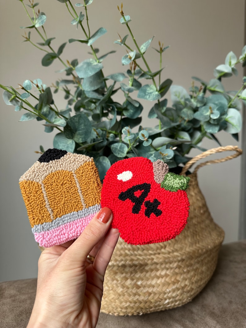 May include: Two felt crafts, a yellow pencil and a red apple with a white stem and a black "A+" on it.