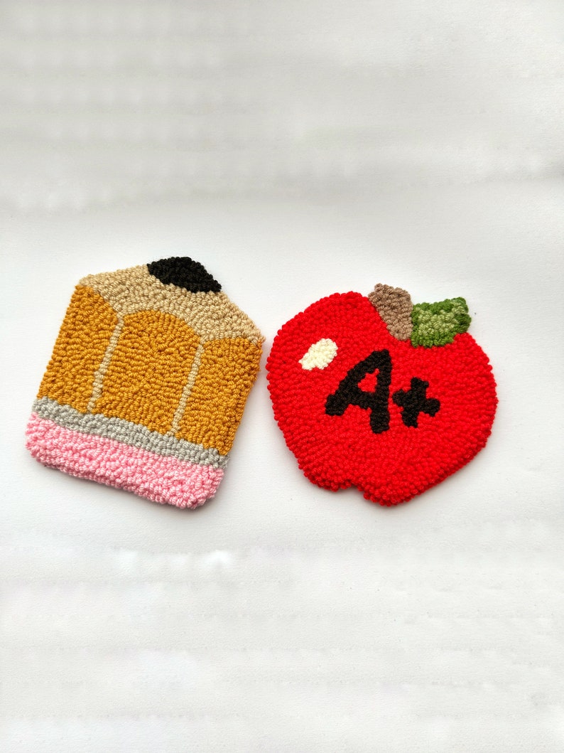 May include: Two felt crafts, a yellow pencil and a red apple with a white A+ on it.