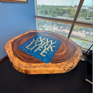 May include: A wooden table with a blue and gold epoxy resin inlay featuring the words "NEW YORK LIFE".