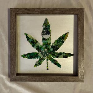 May include: A white ceramic mug with a black handle and the text "But First, Coffee" in a black, handwritten-style font. The mug is on a white surface.