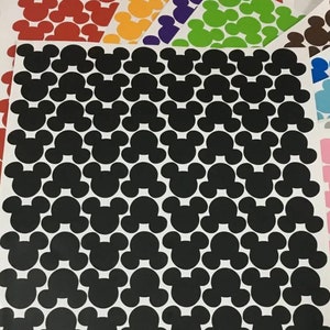 以下が含まれることがあります： 白い背景に黒いミッキーマウスの頭のステッカーのシート。シートは、赤、黄、緑、紫、茶色、青、水色、ピンクなど、さまざまな色のミッキーマウスの頭のステッカーのシートで囲まれています。