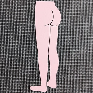 May include: A pink cutout of a person's legs and buttocks. The cutout is on a black textured background.