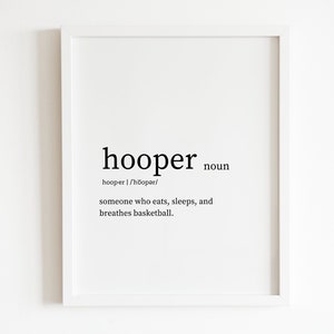 May include: A framed print with the definition of "hooper" in black text. The definition reads: "someone who eats, sleeps, and breathes basketball."
