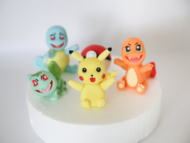 Puede incluir: Cinco figuritas de pastel de personajes de Pokemon de colores, incluyendo Pikachu, Bulbasaur, Charmander, Squirtle y una Pok&eacute; Ball. Las figuritas est&aacute;n hechas de fondant y son perfectas para un pastel de cumplea&ntilde;os con tem&aacute;tica de Pokemon.