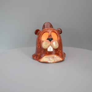 Puede incluir: Una taza de cerámica blanca con un asa negra y el texto "But First, Coffee" en negrita negra. La taza está sobre un fondo borroso, sugiriendo un ambiente acogedor. La taza mide aproximadamente 10 cm de alto.