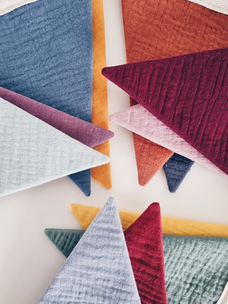 May include: A collection of triangular fabric pieces in various colors, including blue, purple, red, orange, and green. The fabric has a textured, quilted appearance.