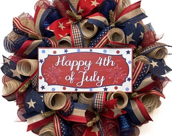 May include: A red, white, and blue Fourth of July wreath with a sign that reads "Happy 4th of July". The wreath is made of burlap, mesh, and ribbon.