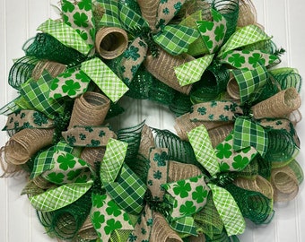 Op de afbeelding: Een groene, bruine en witte St. Patricks Day krans met klaverblad-patroon lint en jute.