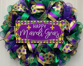 May include: A green, purple, and gold Mardi Gras wreath with a sign that reads "Happy Mardi Gras".