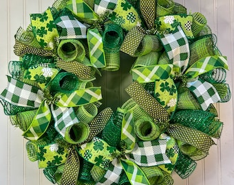 Op de afbeelding: Een groene, witte en zwarte St. Patricks Day krans met klavertjevier en ruitvormige lint accenten.