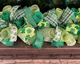 Peut inclure: Une couronne de Saint-Patrick verte et blanche avec un ruban à motif trèfle et un filet vert.