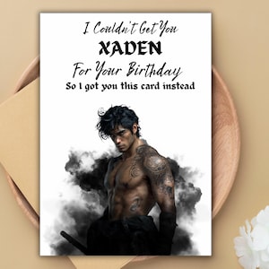 May include: Birthday card with the text "I Couldn't Get You XADEN For Your Birthday So I got you this card instead." The card features a shirtless man with tattoos, surrounded by dark smoke.