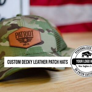 May include: A camouflage trucker hat with a brown leather patch that says "PATRIOT AND CO."  The hat is on a wooden surface with a white and red American flag in the background.  The image also includes a round sticker with the text "PERSONALIZED PATCH YOUR LOGO HERE War Buffalo & Co. OR ENTER CUSTOM TEXT".