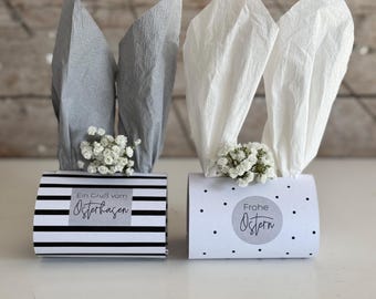 May include: Two Easter bunny gift boxes with white and gray tissue paper ears. One box has black and white stripes and says "Ein Gruß vom Osterhasen". The other box has white polka dots and says "Frohe Ostern".