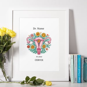 Könnte beinhalten: Ein weißer gerahmter Druck mit einer rosa Gebärmutter, umgeben von bunten Blumen. Der Text "Dr. Name" und "At your CERVIX" ist unter dem Bild gedruckt.