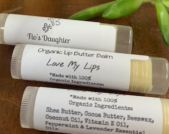 May include: Three white tubes of organic lip butter balm with labels that read "Flo's Daughter Organic Lip Butter Balm Love My Lips *Made with 100% Organic Ingredients" and "*Made with 100% Organic Ingredients Shea Butter, Cocoa Butter, Beeswax, Coconut Oil, Vitamin E Oil, Peppermint & Lavender Essential Oils."