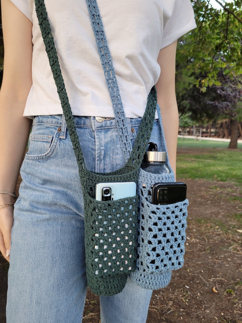 May include: A crocheted crossbody bag with two pockets, one green and one blue, holding a phone and a water bottle.