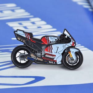 May include: A motorcycle pin with a light blue, red, and black color scheme. The pin features the text "ASPIRA MODULA" and "FEDERAL OIL". The motorcycle has a number "1" on the side.