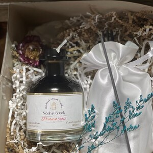 May include: A glass bottle of  'Noah's Spark Prosecco Rose'  coco vegan reed diffuser, hand-poured in a white gift box with shredded paper and a white satin bag with a black reed diffuser stick.