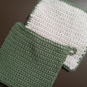 以下が含まれることがあります： 緑と白の2枚の編み物製の食器洗い用布。布はシンプルな編み方でできており、表面に凹凸があります。