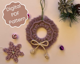 Könnte beinhalten: Ein digitales PDF-Muster für einen gehäkelten Kranz-Anhänger. Der Kranz ist lila mit einer beige Schleife und Quasten. Der Anhänger hängt an einer grünen Schnur.