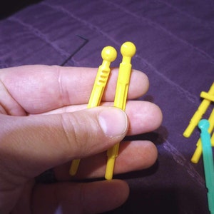 May include: Two yellow plastic rods with rounded ends. The rods have a series of small holes along their length.