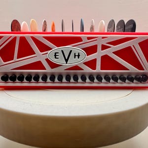 Van Halen guitar pick holder.  Red, Black and White Holds up to 13 picks!