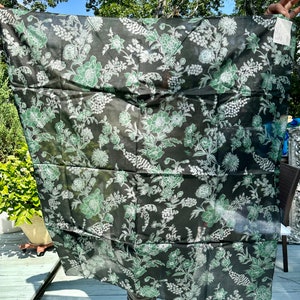 May include: A black sheer scarf with a white and green floral pattern.