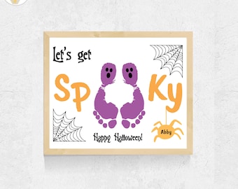 May include: A framed Halloween art print featuring the text Let's get Spooky with two purple footprint ghost illustrations in the center. The design includes black spiderwebs in the corners, an orange spider with the name Abby, and Happy Halloween text.
