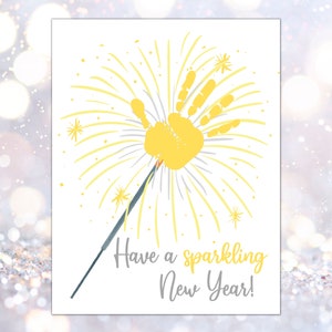 May include: A yellow handprint with gray lines radiating out from it, resembling a firework. The text "Have a sparkling New Year!" is written below the handprint.