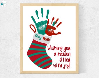 May include: A red and green striped stocking with the names Abby and Noah written on it. Two handprints, one green and one red, are above the stocking. The text "Wishing you a season filled with joy!" is below the stocking.
