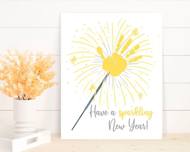 May include: A yellow handprint in the shape of a firework with the text "Have a sparkling New Year!"