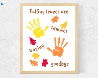 May include: A framed print with the text "Falling leaves are summer waving goodbye" and two handprints, one yellow and one orange, surrounded by red, orange, and yellow leaves.