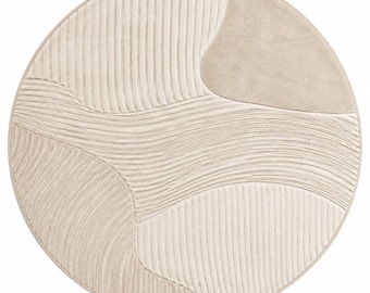 May include: A circular area rug in shades of cream and beige featuring a textured surface with carved, flowing lines and smooth, solid-colored sections. The design consists of alternating patterns of vertical and horizontal grooves.