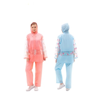 May include: Two raincoats, one pink and one blue, with a transparent mesh design and floral accents. Both raincoats have a hood and long sleeves.