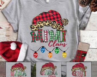 May include: A gray t-shirt with a red and black plaid Santa hat with a leopard print trim. The text "Mimi Claus" is written in green, red, and white letters with a string of Christmas lights with names on them. Three other shirts are shown below with the text "Nana Claus", "Grandma Claus", and "Gigi Claus".