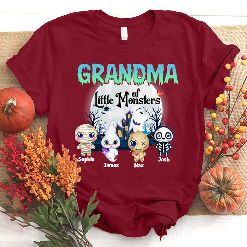 K&ouml;nnte beinhalten: Rotes T-Shirt mit dem Text "Oma der kleinen Monster" in Gr&uuml;n und Wei&szlig;. Unter dem Text befinden sich vier Comic-Monster mit den Namen "Sophia", "James", "Max" und "Josh" darunter.