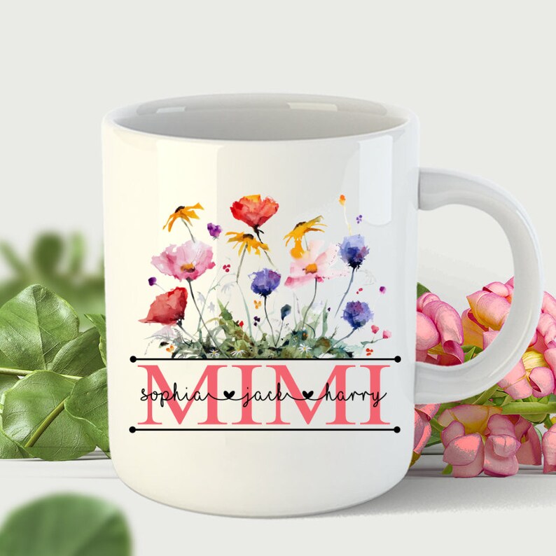 May include: White ceramic mug with a watercolor floral design featuring colorful flowers and green leaves. The text "MIMI" is printed in black with the names "sophia", "jack", and "harry" printed in pink below the floral design.