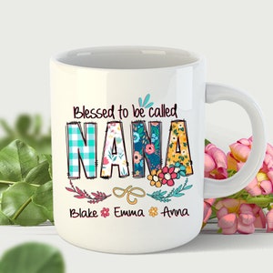 May include: White ceramic mug with a floral design and the text "Blessed to be called NANA" with the names "Blake, Emma, Anna" below.