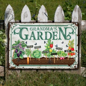 May include: A vintage-style metal sign with the text "Grandma's Garden" in green lettering. The sign features illustrations of various vegetables and flowers, each labeled with a name, such as Ethan, Julia, Emma, Lucas, Tyler, and Kim.