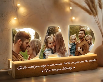 May include: A wooden light-up sign that spells "DAD" with a family photo in each letter. The sign has a message that reads "To the world you may be one person, but to us you are the world. We love you, Daddy."