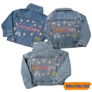 Puede incluir: Tres chaquetas vaqueras con nombres bordados, Penelope, Kaylynn y Kamryn. Cada chaqueta tiene un arco&iacute;ris, un sol y estrellas.