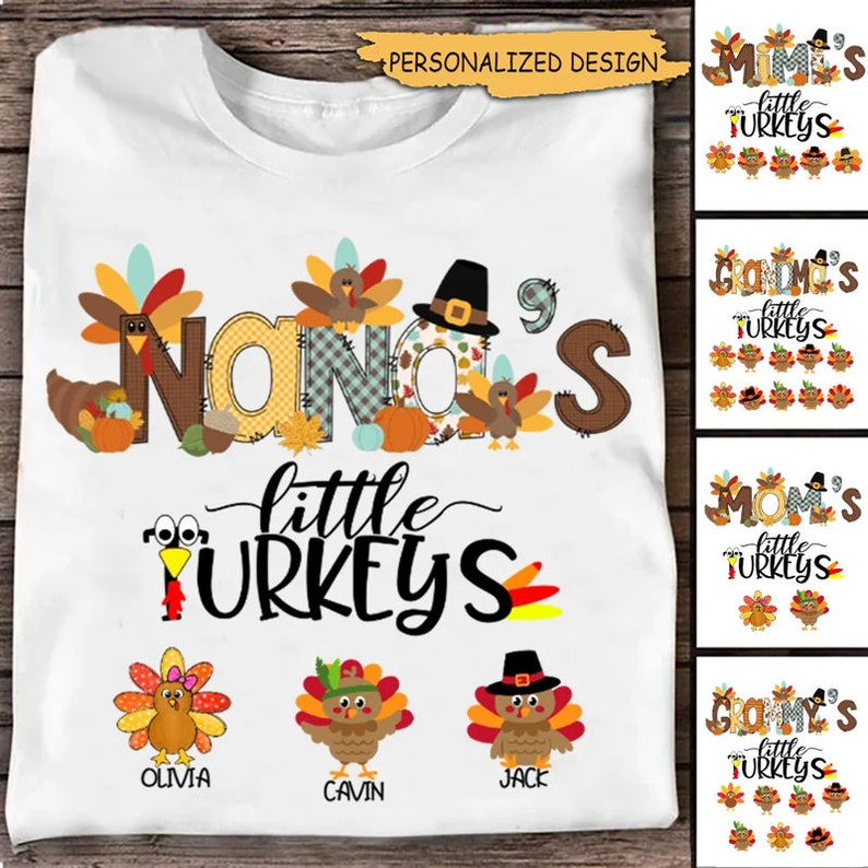May include: White t-shirt with a Thanksgiving-themed design featuring the text "Nana's little turkeys" with a patchwork style font. The design includes a turkey with a pilgrim hat and a pumpkin. Three smaller turkeys are below the text with the names Olivia, Jack, and Cavin.