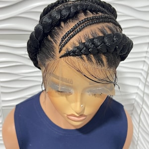 May include: A black braided wig with a lace front. The wig features a combination of thick, circular braids and smaller, linear braids. The wig is styled on a mannequin head, with a navy blue top.