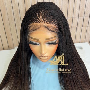 Op de afbeelding: Een donkerbruine lace front pruik met micro-vlechtjes, een gedefinieerde middenscheiding en babyhaartjes langs de haarlijn. De pruik wordt getoond op een etalagepophoofd met het logo ZBL Zion BellaLuxe Where Luxury meets every strand.