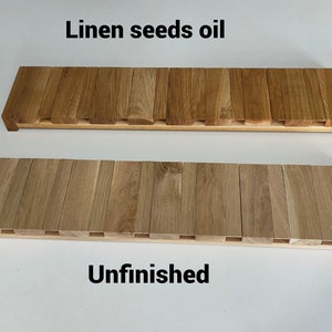 May include: Two wooden planks, one finished with linen seed oil and the other unfinished. The planks are made of light brown wood and have a rectangular shape.