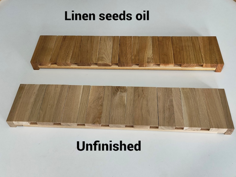 May include: Two wooden planks, one finished with linen seed oil and the other unfinished. The planks are made of light brown wood and have a rectangular shape.