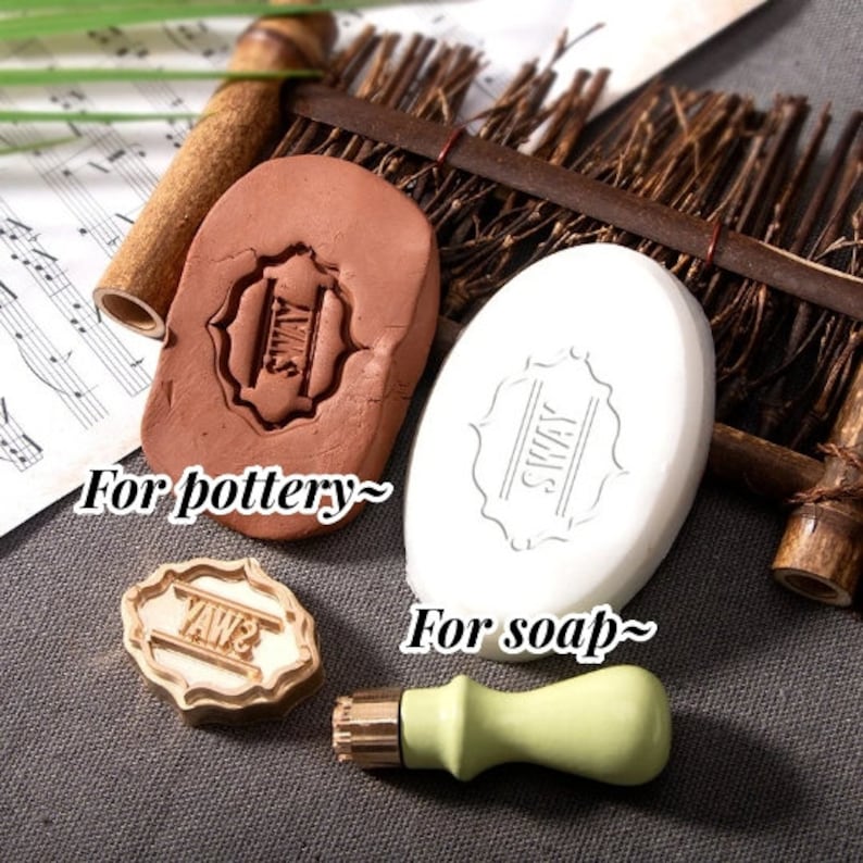 May include: An assortment of craft stamps for pottery and soap. The image shows a brown clay stamp with the word "SWAY", a white oval soap with the same design, and a gold and green stamp with the word "YAWS".