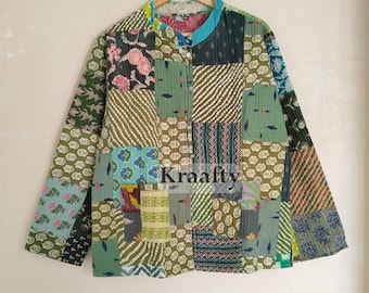 Puede incluir: Chaqueta patchwork con cuello mandarín, con una variedad de cuadrados de tela estampada en tonos verdes, marrones y azules. La chaqueta está colgada en una percha de madera. El texto "Kraafty" es visible en la chaqueta.